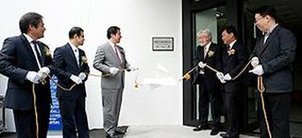 Zeremonie zur Eröffnung des Labors: 6 Herren in Anzug und weißen Handschuhen halten gemeinsam ein Band