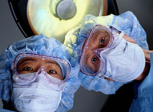 Zwei Mediziner die auf OP-Tisch schauen